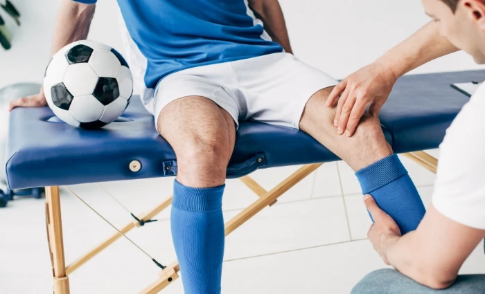 young soccer player being assessed on table